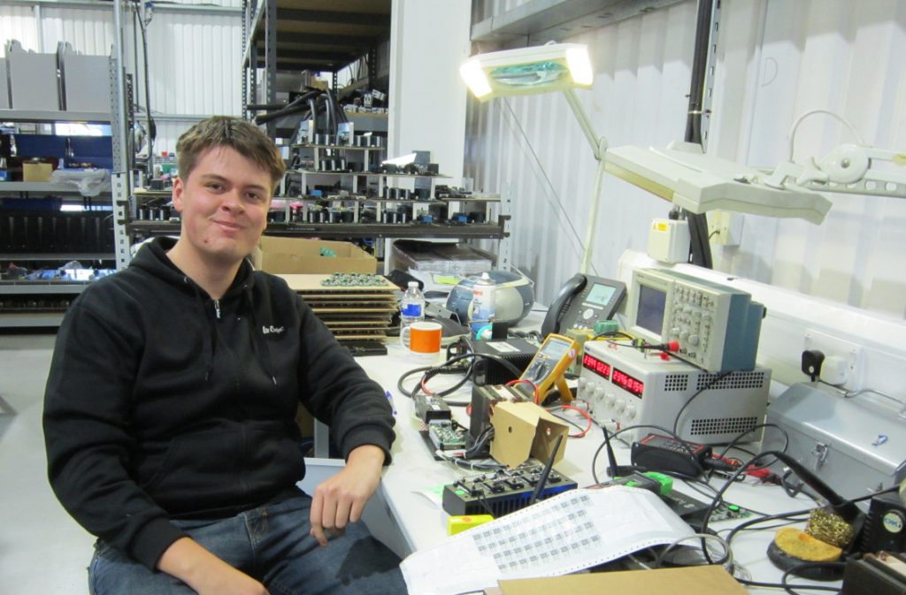 Daniel Baron new hire at Power Gems, at the test engineer work station in Manchester, UK
