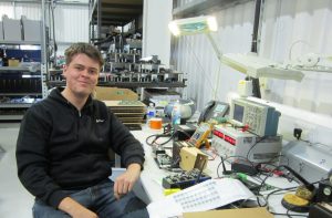 Daniel Baron new hire at Power Gems, at the test engineer work station in Manchester, UK