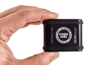 A small black device called GEMboost being held between finger and thumb. With Power Gems logo and Max 1.25A/15W writing and GEMboost name shown white on black background